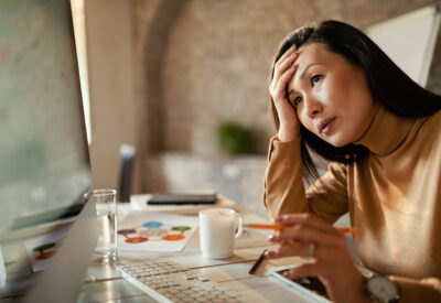 pensive-asian-businesswoman-working-on-a-computer